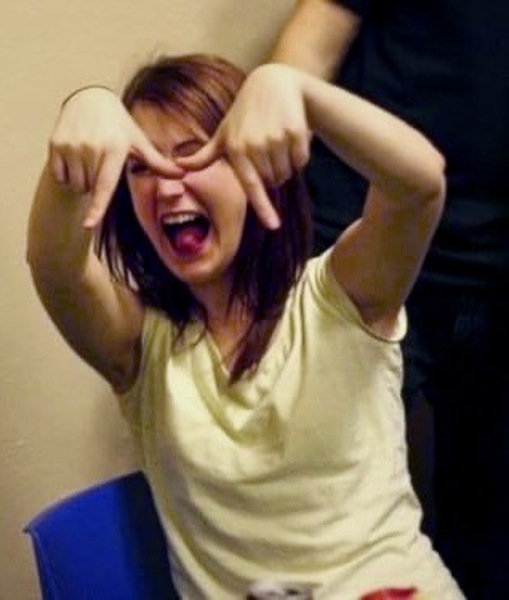 a woman sitting on a chair with her hands up