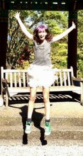 a girl jumping in the air with her arms outstretched