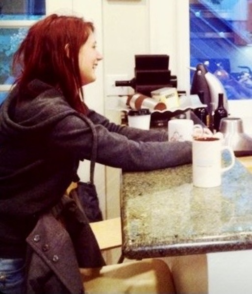 a woman sitting at a counter with a cup