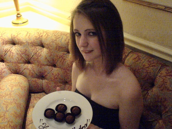 a woman sitting on a couch holding a plate of chocolate