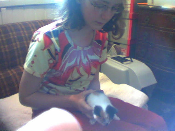 a woman sitting on a couch holding a cat