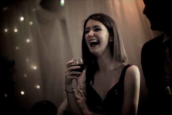 a woman in a black dress holding a glass