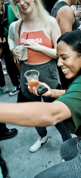 a woman is holding a drink in her hand