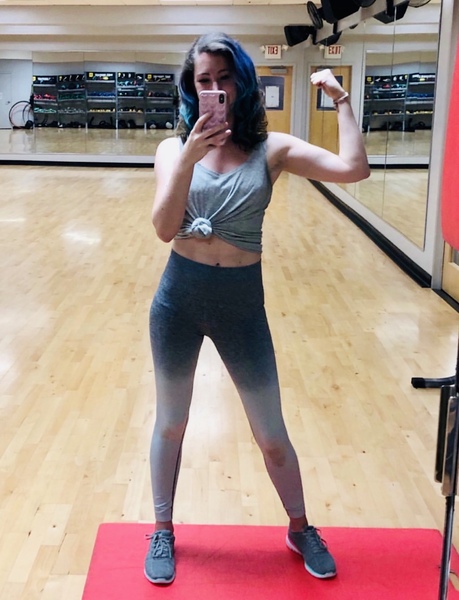 a woman in a gym room taking a selfie