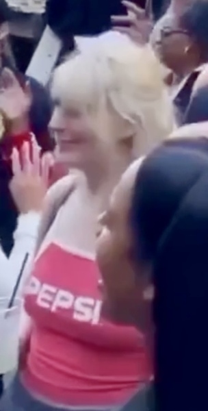 a woman is seen in the crowd as she is surrounded by a crowd