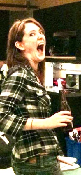 a woman in a plaid shirt is singing into a microphone