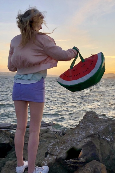 a woman standing on rocks near the watermelon