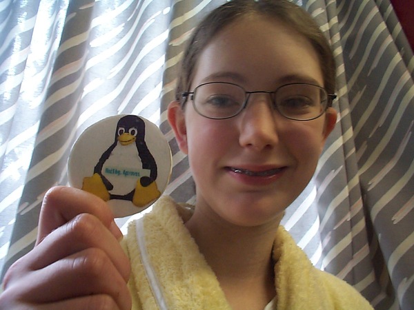 a girl in a bath robe holding a penguin shaped pin