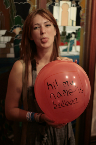 a woman holding a red balloon with writing on it