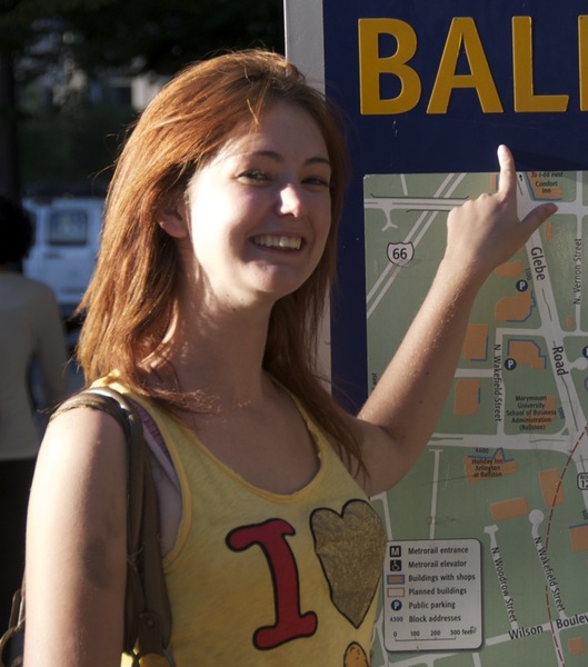 a woman points at a sign that says ball