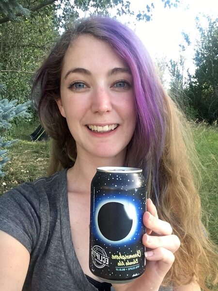 a woman holding a can of beer in her hand