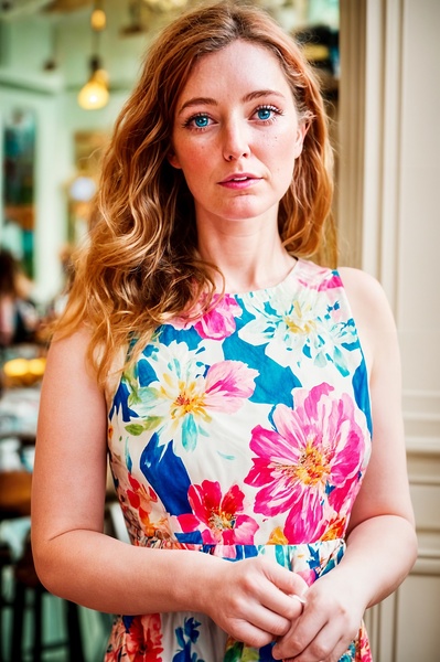 a woman in a floral dress is posing for a picture