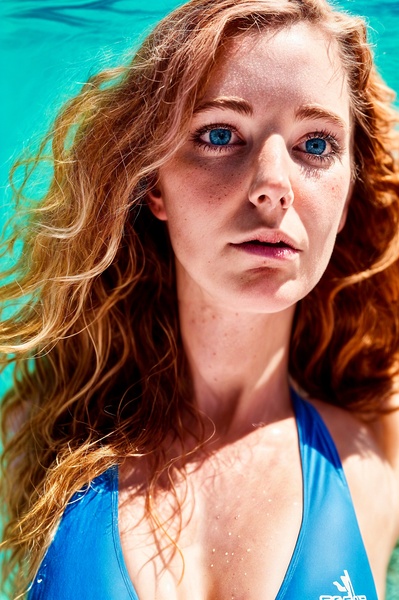 a woman in a blue bikini top standing in a pool