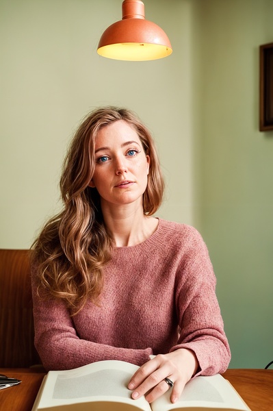 a woman sitting at a table with a book