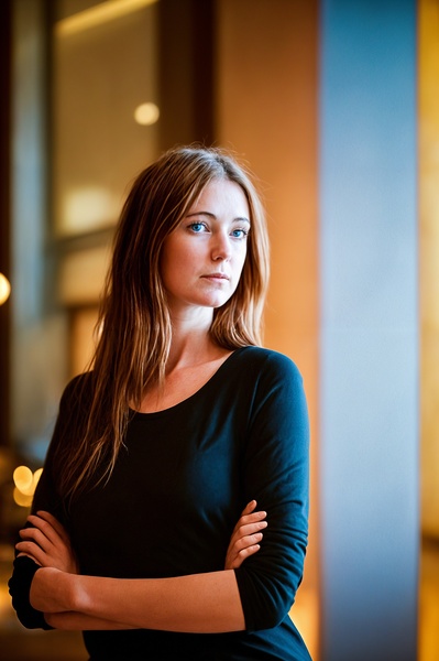 a woman standing in a room with her arms crossed