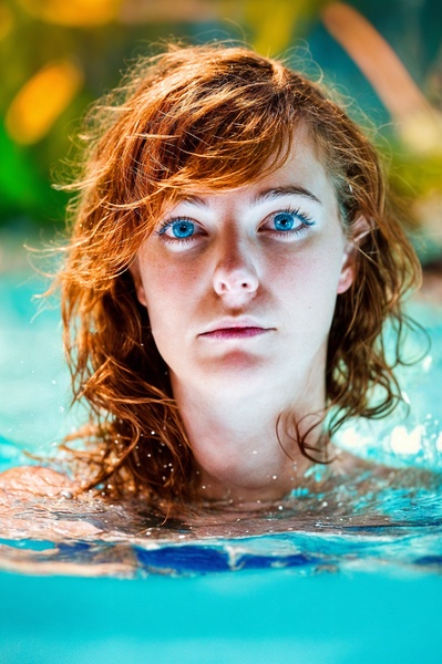 a woman with long hair swimming in a pool