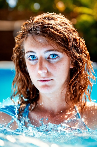 a woman in a pool with water splashing around her