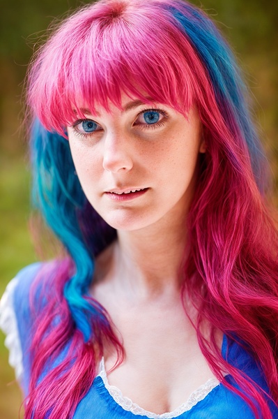 a woman with pink hair and blue eyes