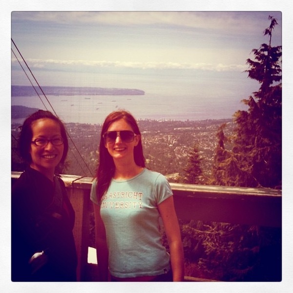 two women standing on a balcony overlooking the water