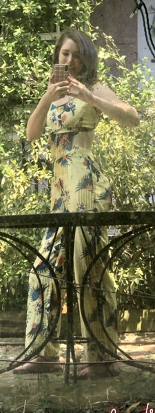 a woman in a yellow dress standing on a bench