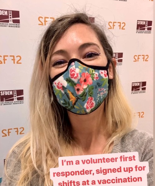 a woman wearing a face mask with flowers on it ™ Mmavo

junteer first
-¢ responder, signed up for «
', ehifts ata vaccination .