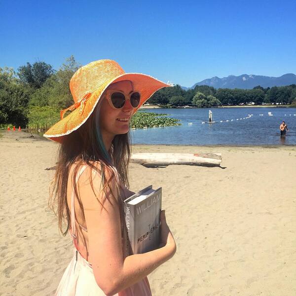 a girl in a hat and sunglasses on a beach