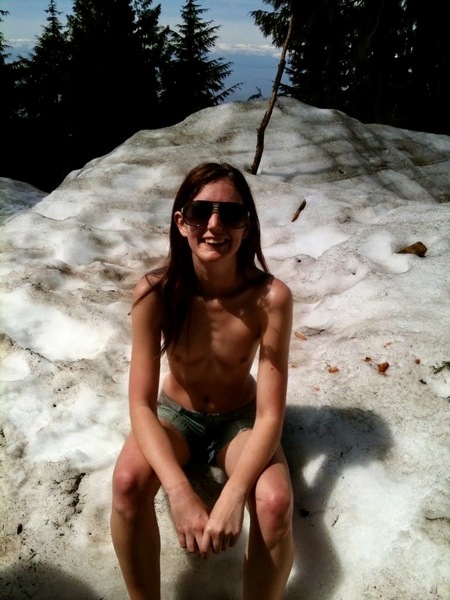 a woman sitting on a rock in the sand