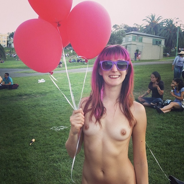 a naked girl with pink hair holding red balloons