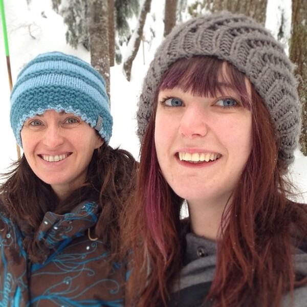 two women are smiling in the snow