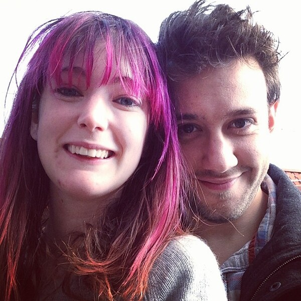 a man and woman with pink hair posing for a picture