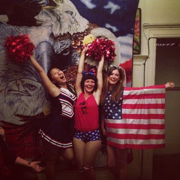 two girls in patriotic outfits holding american flags