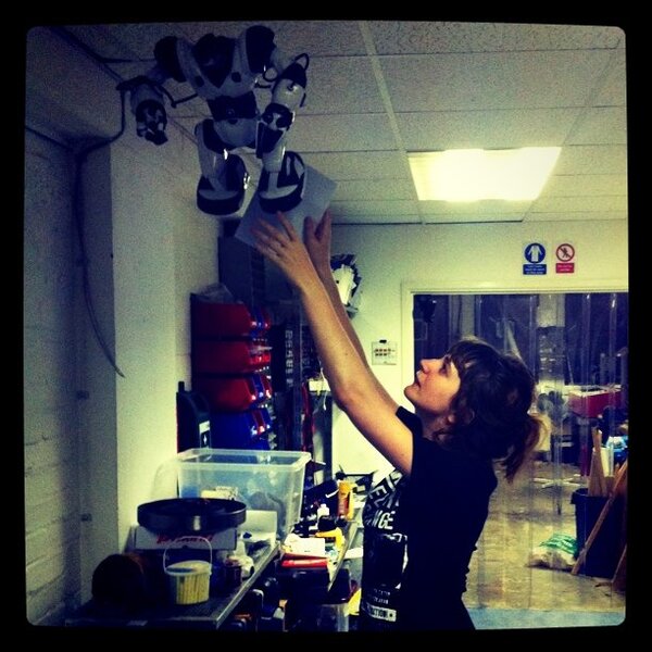 a woman is reaching up a light fixture