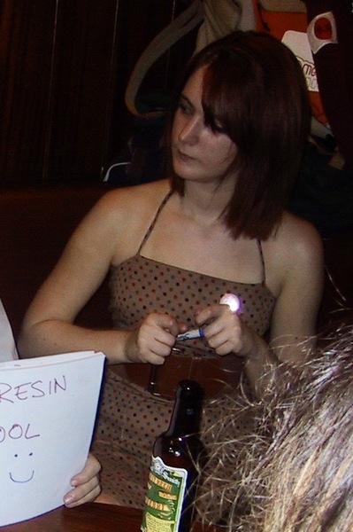 a woman sitting at a table with a sign