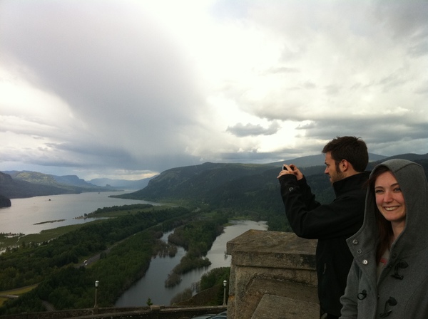 a man and woman taking a picture of a lake