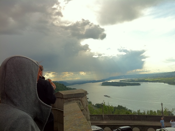 a person sitting on a ledge looking at a lake