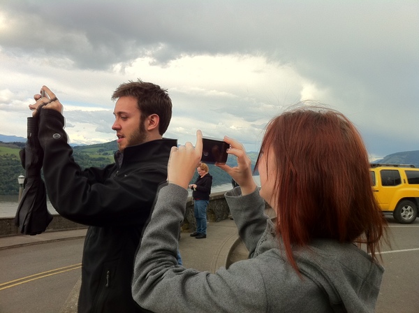 a man and woman taking a picture of a yellow truck