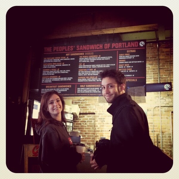 a man and woman standing in front of a menu