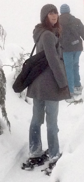 a woman is walking through the snow