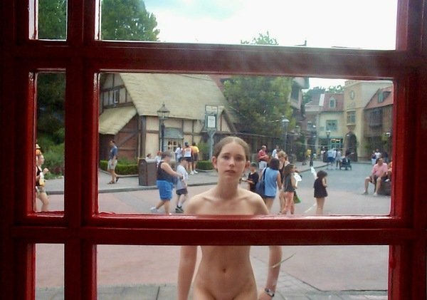 a naked woman standing in front of a window