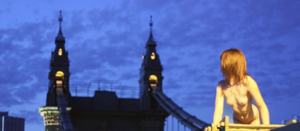 a woman sitting on a bench in front of a clock tower