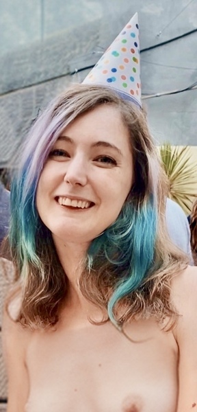 a woman with a birthday hat and a cake