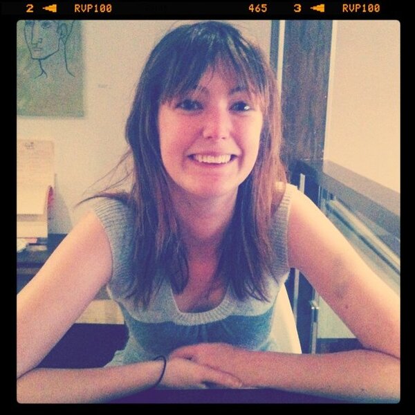 a woman sitting at a table with her arms crossed