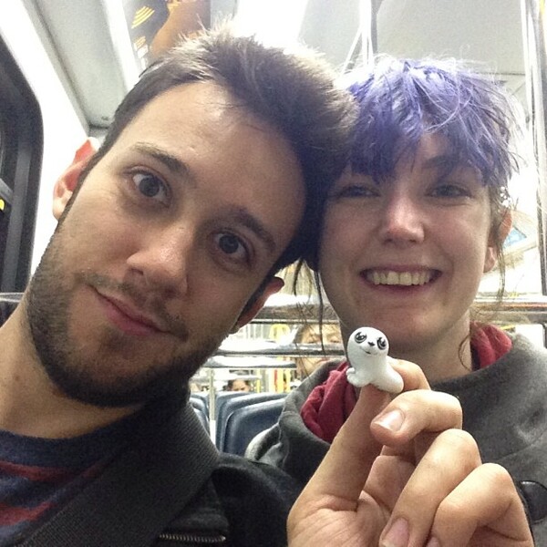 a man and woman are smiling and holding a small object