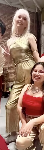 a group of women in red dresses dancing