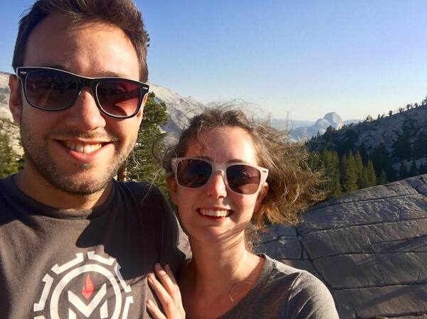 a man and woman standing on top of a mountain