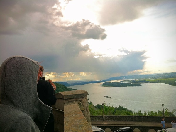 a person sitting on a ledge looking at a lake