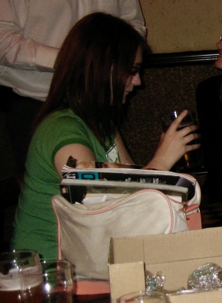 a woman sitting at a table with a cellphone