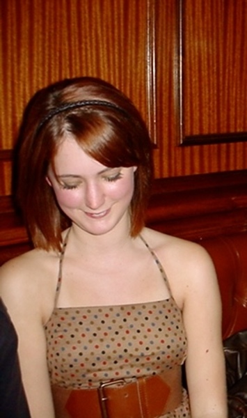 a woman sitting at a table with a cake