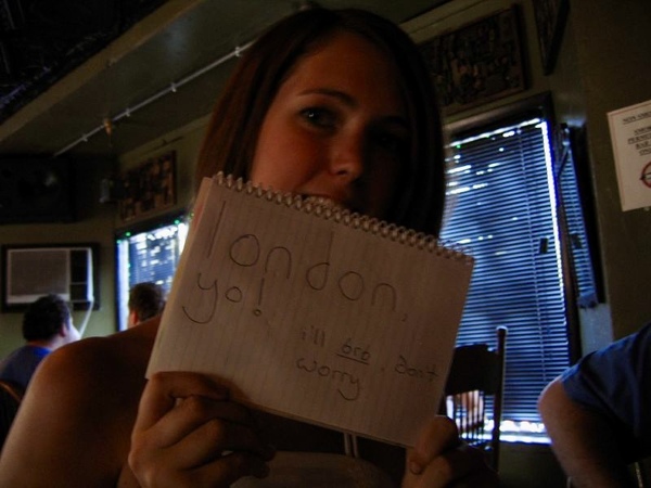 a girl holding up a piece of paper with the words