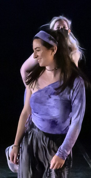 a woman in a purple shirt and black pants